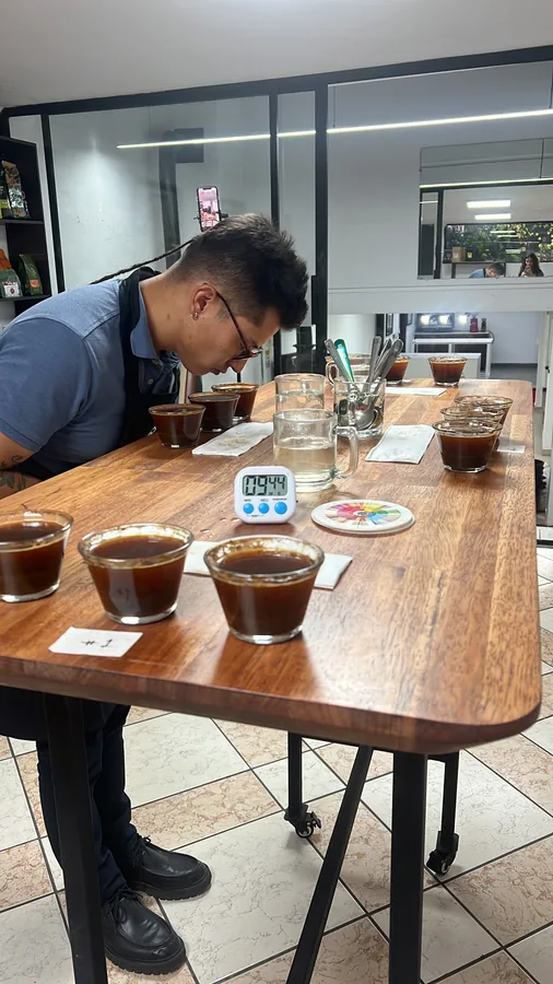 Barista en solitario catando muestras de café con bata de laboratorio