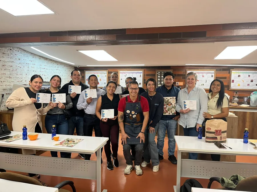 Grupo de graduados sosteniendo sus certificados en el salón de clases