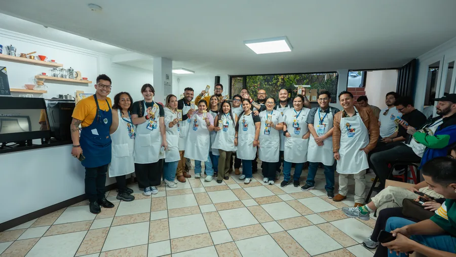 Grupo completo de participantes de la academia posando en delantales blancos