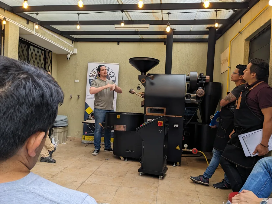Instructor explicando el proceso junto a la tostadora y el panel de control