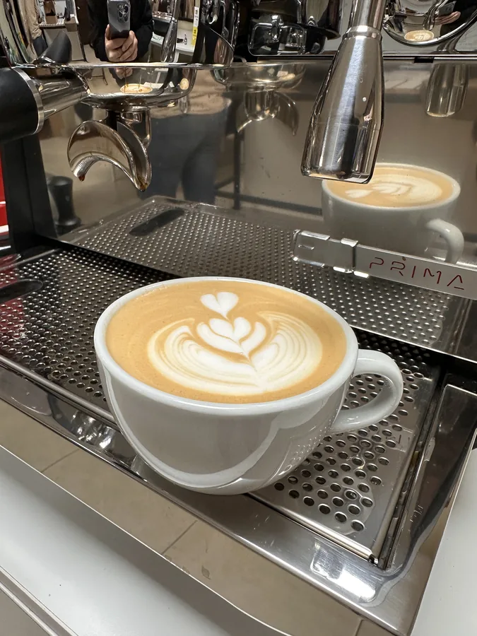 Primer plano de una taza con arte latte en patrón de corazón